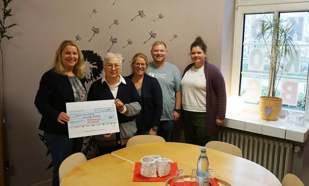 Britta Bethe übergibt den symbolischen Scheck ans Team der Lebenshilfe