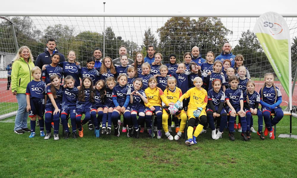 Mädchenfußballmannschaften mit ihren Trainern im Gruppenfoto