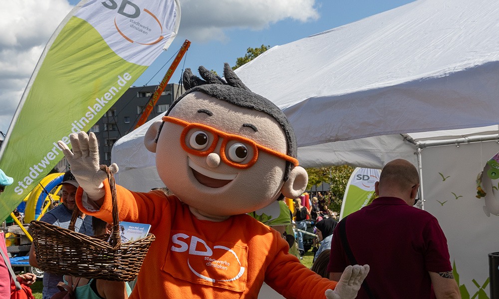 DIN-Maskottchen winkt