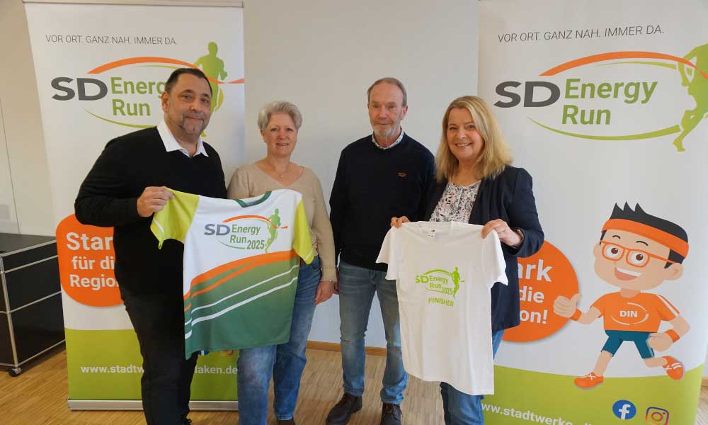 Manni Feldkamp und Petra Pelzer von Marathon Dinslaken, Markus Kuhlmann vom SUS09 und Britta Bethe von den Stadtwerken Dinslaken zeigen die Energy Run Shirts 2025