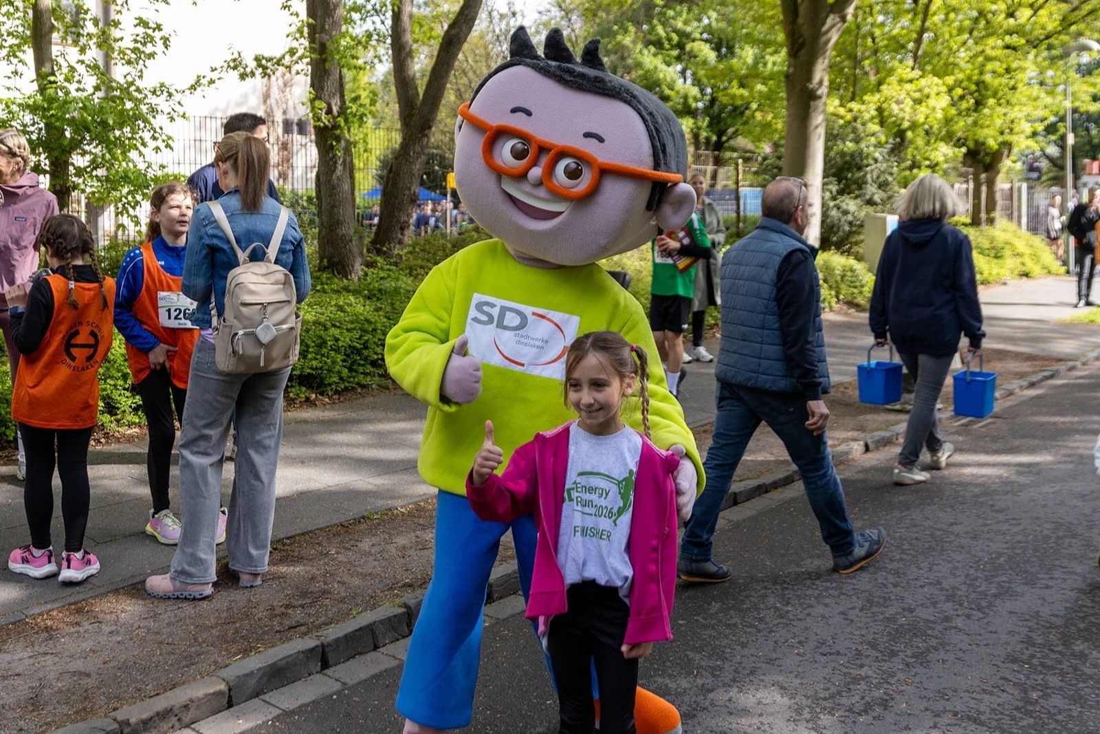 DIN-Maskottchen posiert mit einem Mädchen