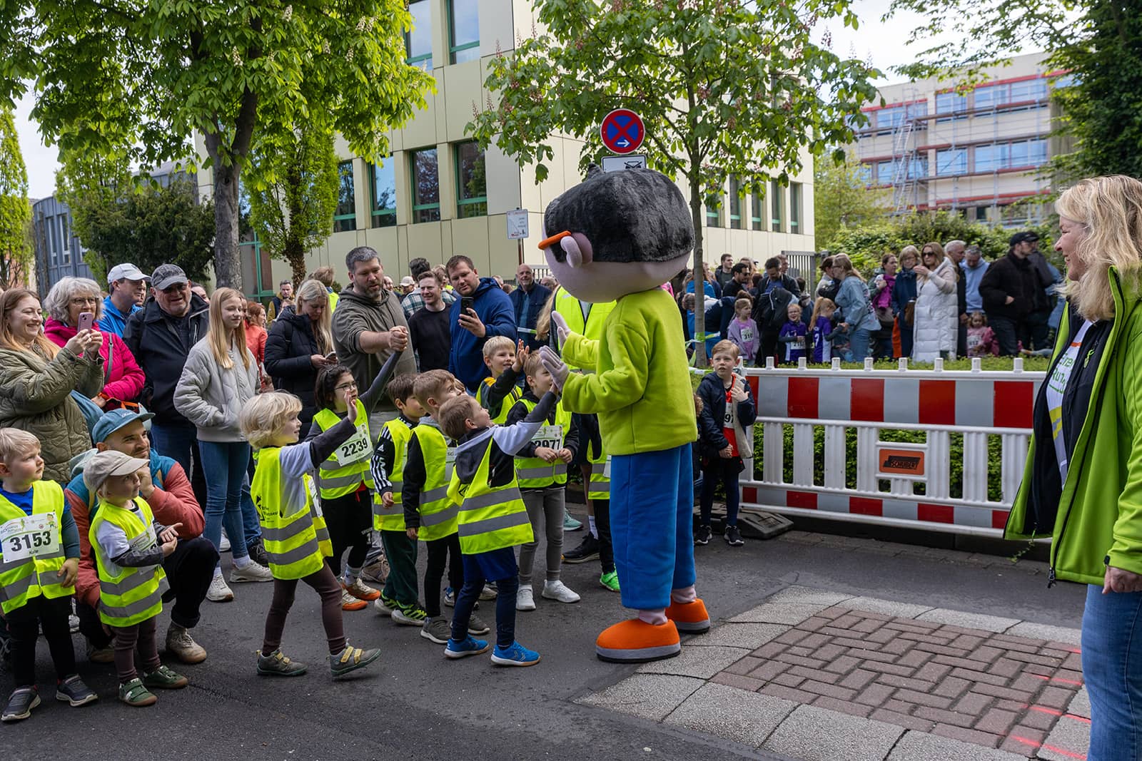 DIn-Maskottchen macht High Five mit den Bamibini-Startern
