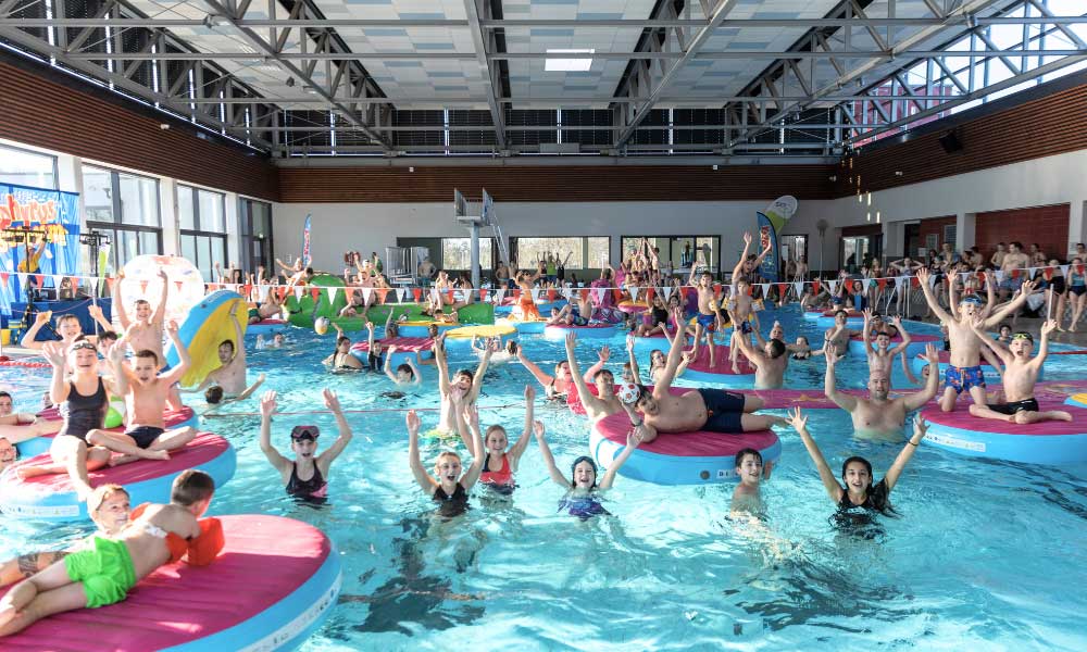 Kinder und Erwachsene haben Spaß im Dinamare beim Energy Splash und reißen die Arme vor Begeisterung hoch