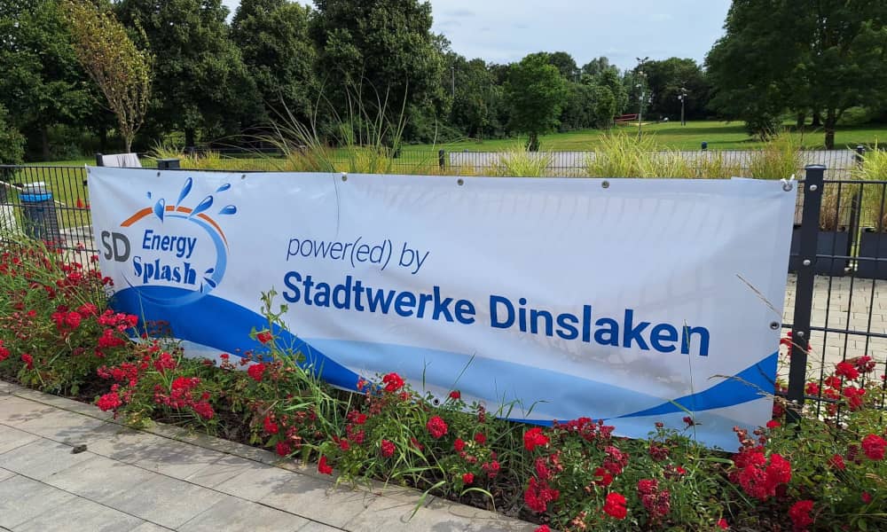 Ein "Energy Splash powered by Stadtwerke Dinslaken"-Banner am Zaun des DINamare