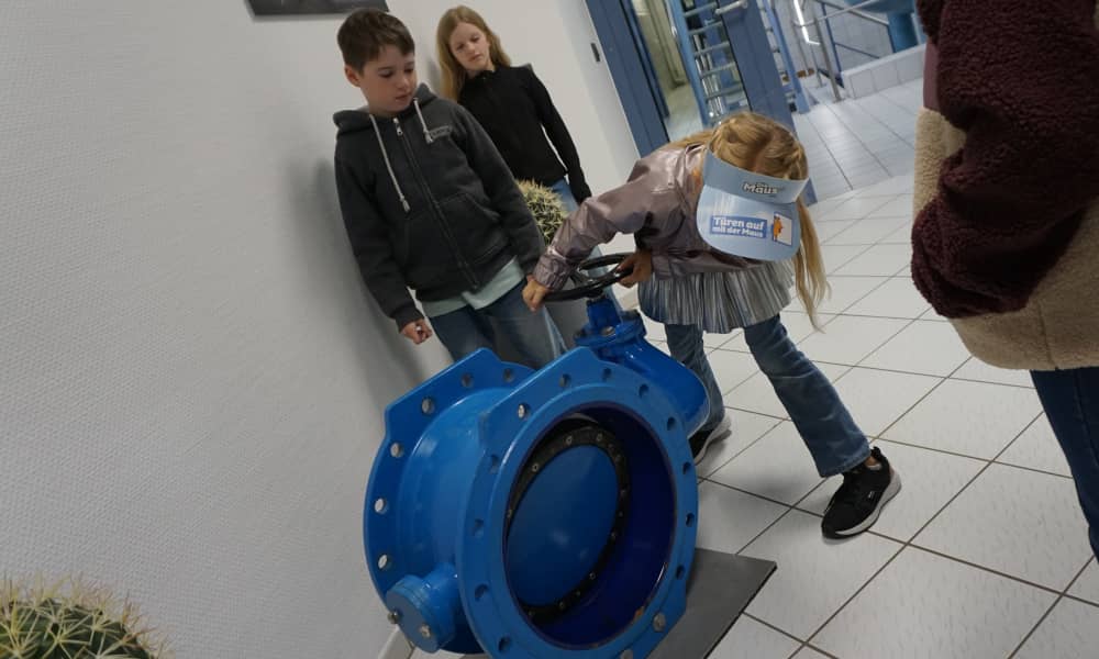 Ein Mädchen schiebert eine Wasserleitung ab
