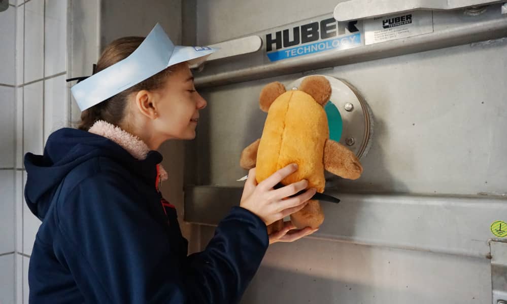Mädchen und Plüschmaus schauen in einen Wassertank