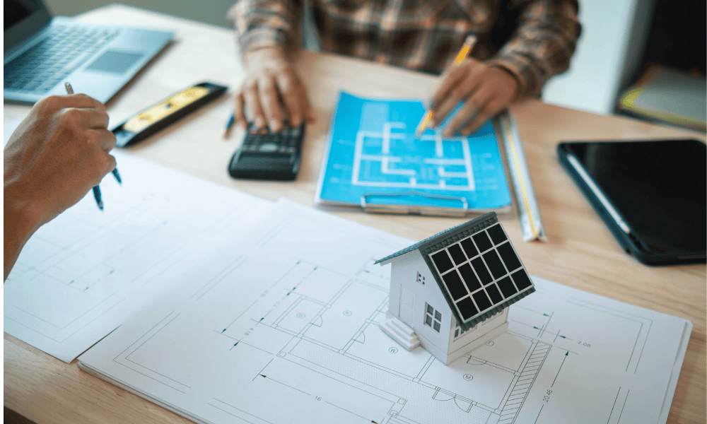Eine Hand stellt das Thermostatventil an der Heizung ein