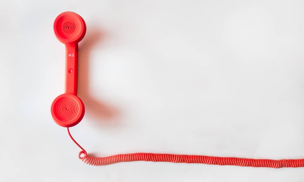 Ein roter Telefonhörer mit passender Schnur