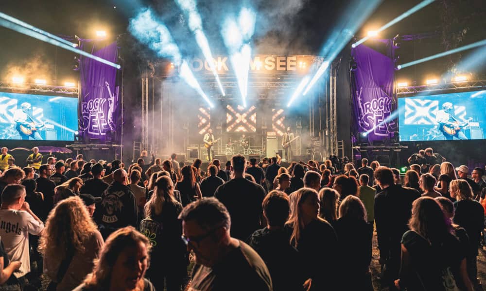 Festivalbesucher erleben eine Bühnenshow bei Rock am See Tender.