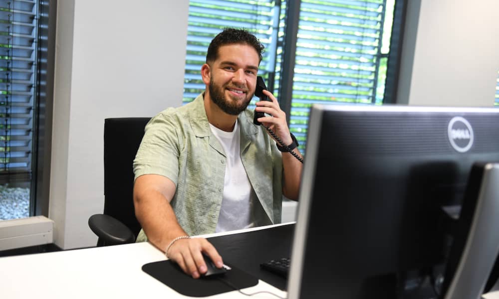 Ein Mitarbeiter am Telefon vor dem PC