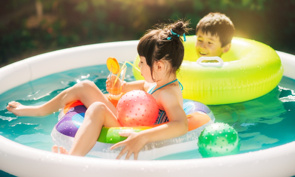 Zwei Kinder planschen im Swimming-ool.