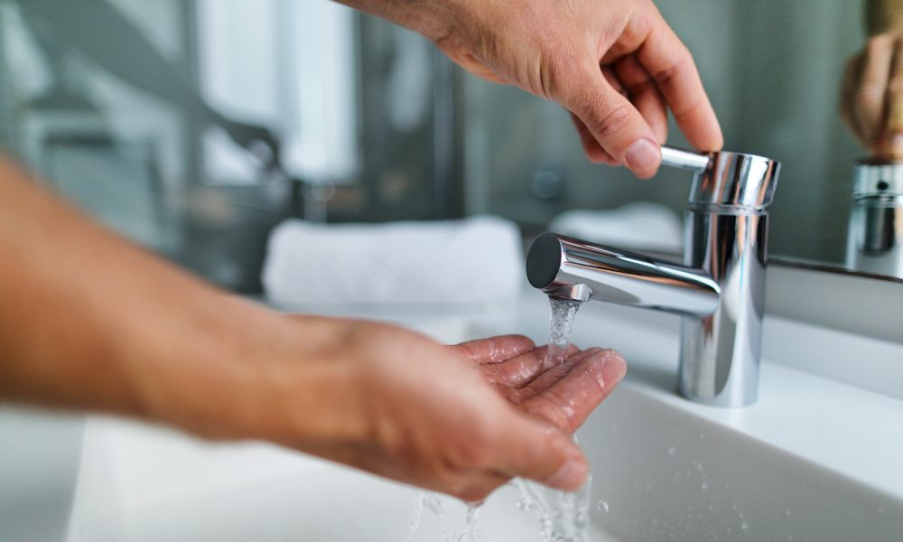 Ein Mann wäscht sich am Waschbecken die Hände.