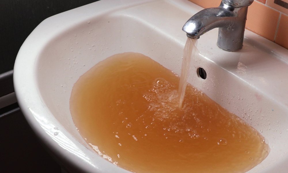 dreckiges Wasser fließt aus einer Küchenarmatur