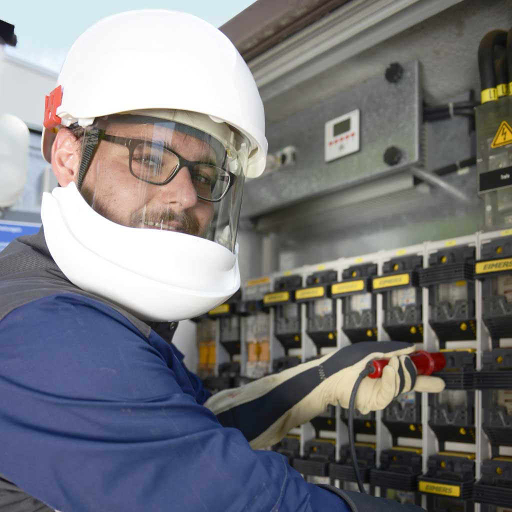 Stadtwerke-Mitarbeiter prüft Strom an einer Trafostation